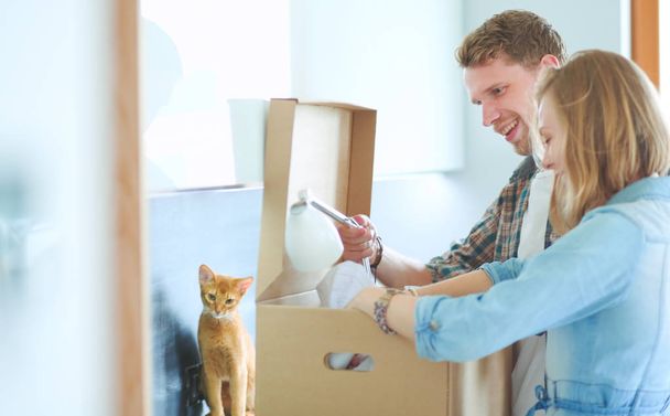 Young couple carrying big cardboard box at new home.Moving house - Photo, image