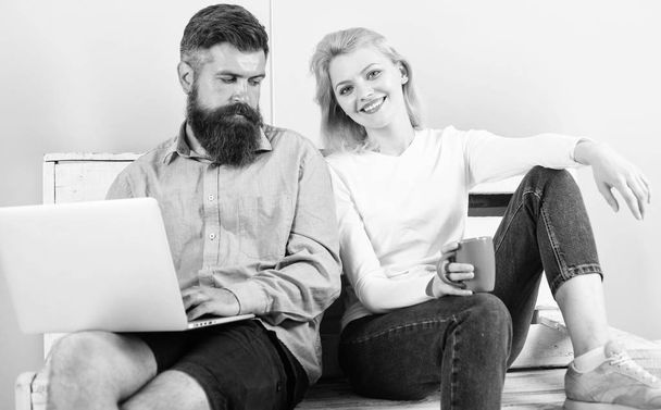 Girl enjoy drink while husband freelancer works with laptop. Freelance benefits. Man works as internet technologies expert on freelance. Woman smiling face drink tea or coffee near man working - Photo, image