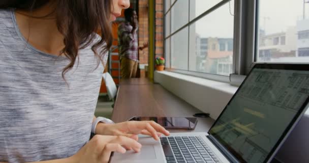 Side view of Caucasian businesswoman working on laptop in a modern office. She is sitting near window. 4k - Footage, Video