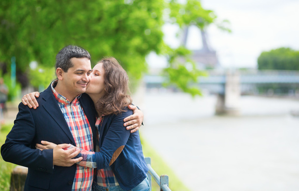 Happy couple kissing near the Seine - Φωτογραφία, εικόνα