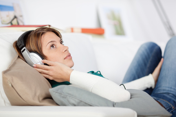 Woman listening to music on the sofa - Zdjęcie, obraz