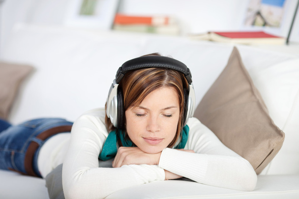Blissful woman enjoying music on her headphones - Zdjęcie, obraz