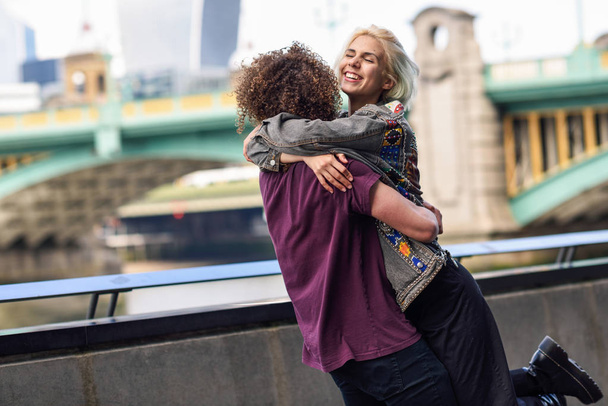 テムズ川に架かるサウスウォーク橋の近くで抱き合う幸せなカップル、ロンドン - 写真・画像