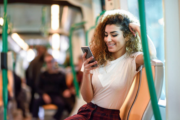 Metro treninin içindeki Arap kadın akıllı telefonuna bakıyor - Fotoğraf, Görsel