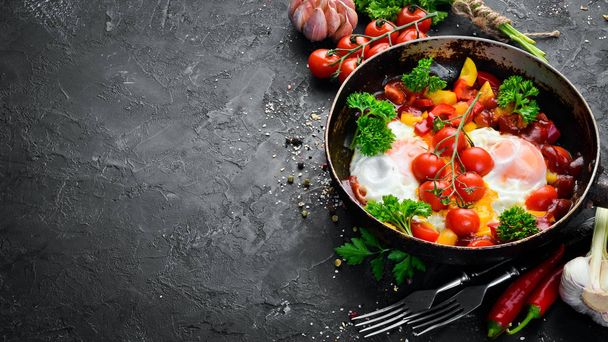 Shakshuka Eggs with tomatoes and vegetables in a frying pan. Breakfast. Top view. Free space for your text. - Valokuva, kuva