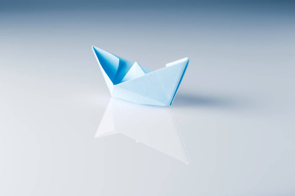 papírová loď s odrazem na lesklém povrchu - Fotografie, Obrázek