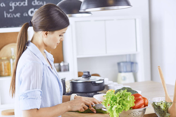 Een jonge vrouw bereidt gerechten in de keuken. Gezonde voeding - fruit - Foto, afbeelding