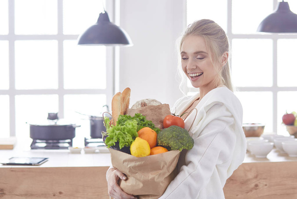 Giovane donna che tiene borsa della spesa con verdure Standi
 - Foto, immagini