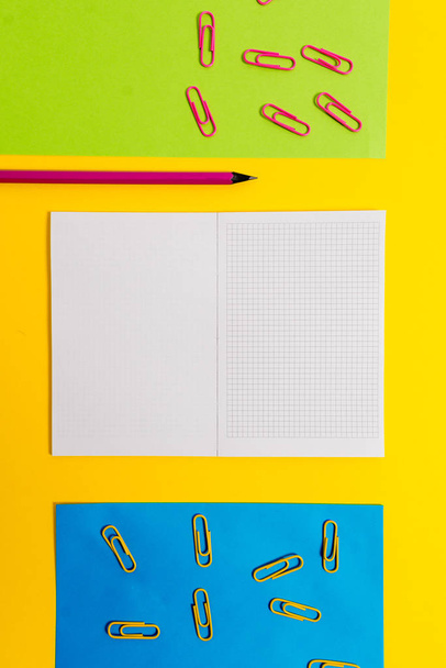 Κενό τετράγωνο σημειωματάριο χρωματιστά φύλλα χαρτί κλιπ μολύβι επισήμανσης μαρκαδόρος στυλό απλό χρώμα φόντο. Κενές σημειώσεις σημαντικές μελλοντικές εκδηλώσεις σχολείο γραφείο στο σπίτι - Φωτογραφία, εικόνα