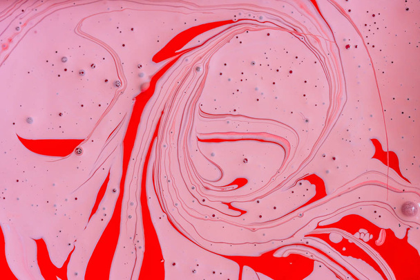 die Mischung der beiden flüssigen Farben rot und rosa. schöne abstrakte rosa rot zweifarbigen Hintergrund. Färbung Acryl Latex Farbe - Foto, Bild