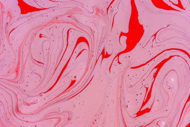 die Mischung der beiden flüssigen Farben rot und rosa. schöne abstrakte rosa rot zweifarbigen Hintergrund. Färbung Acryl Latex Farbe - Foto, Bild