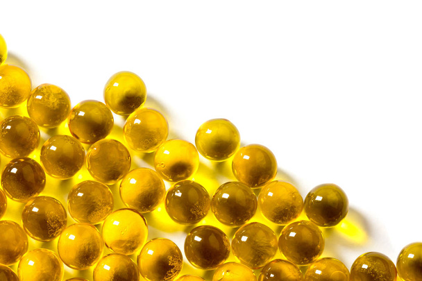 orange spherical ball capsules of fish oil selective focus isolated on white background - Photo, Image