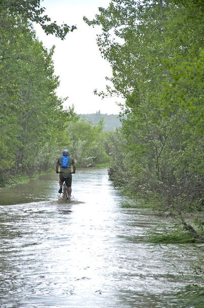 Andar de bicicleta numa via inundada
. - Foto, Imagem