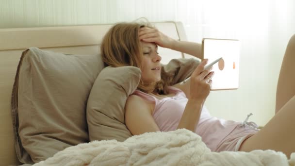 Γυναίκα στο κρεβάτι χρησιμοποιώντας ένα tablet υπολογιστή. Καλημέρα. - Πλάνα, βίντεο