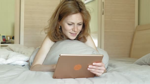 Woman in bed using a computer tablet. Morning - Кадры, видео