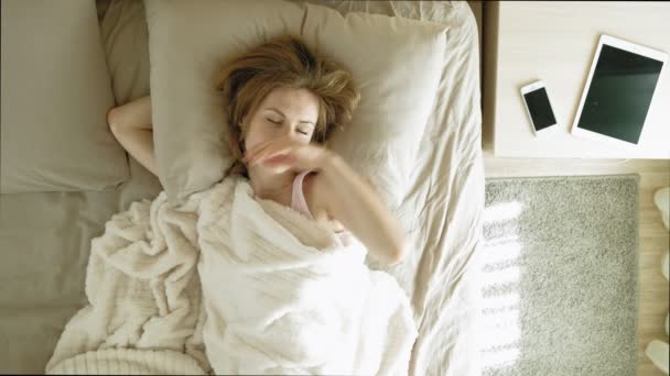 朝。ベッドで女性を目覚めさせる。トップビュー - 映像、動画