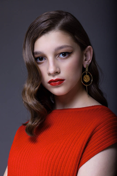 Portrait of a teenager girl in a red sweater.  - Zdjęcie, obraz