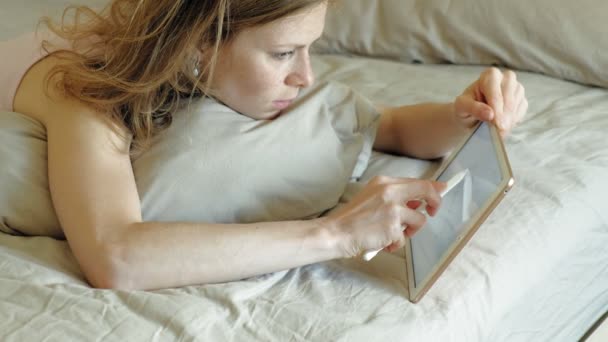 Woman in bed using a computer tablet. Morning - Felvétel, videó