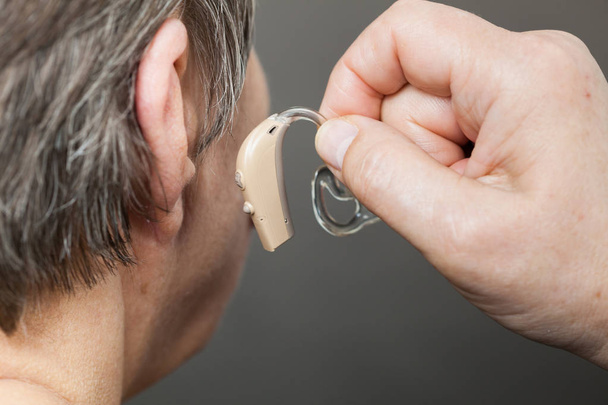 Closeup senior woman using hearing aid - Foto, Imagen