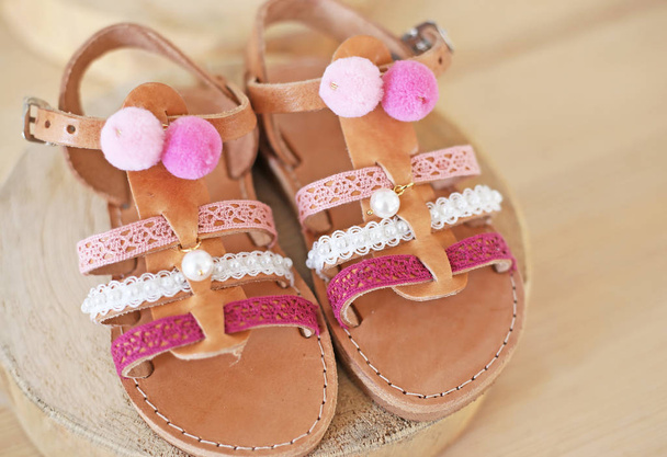 Ελληνικά δερμάτινα σανδάλια με ροζ φούντα και πομ πομ για τα κορίτσια-παιδικά παπούτσια διαφήμιση  - Φωτογραφία, εικόνα