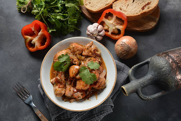 Chakhokhbili - traditional Georgian dish. Chicken stewed with fresh coriander tomatoes and herbs served with a bottle of Georgian wine  - Fotó, kép