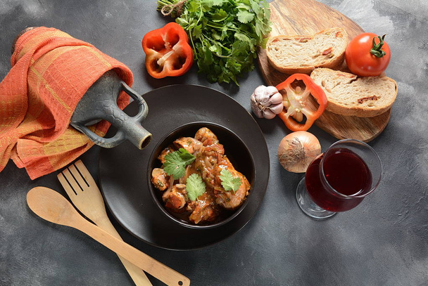 Chakhokhbili - traditional Georgian dish. Chicken stewed with fresh coriander tomatoes and herbs served with a bottle of Georgian wine  - Foto, immagini