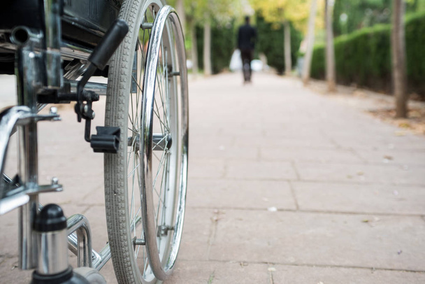Invalidní vozík na vnější straně, v parku na cihlové podlaze - Fotografie, Obrázek