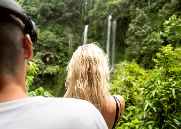 couple in love travels to waterfalls in Indonesia, Bali, rear view - Fotó, kép