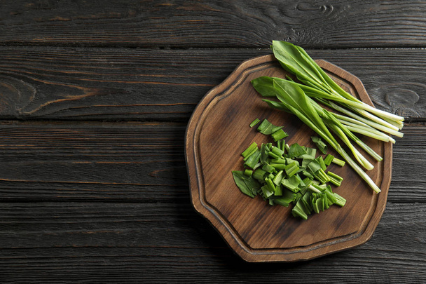 Board with wild garlic or ramson on wooden table, top view. Space for text - Fotoğraf, Görsel