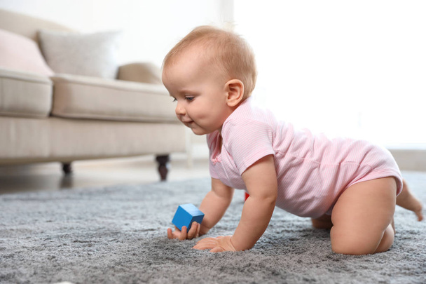 Cute baby girl playing on floor in room. Space for text - 写真・画像