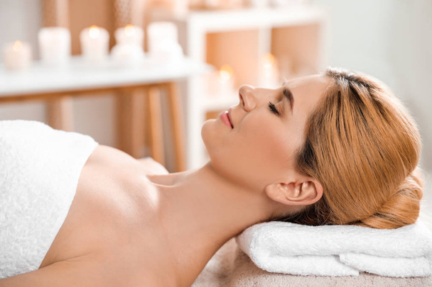 Beautiful woman with silky skin after face mask relaxing in spa salon - Zdjęcie, obraz
