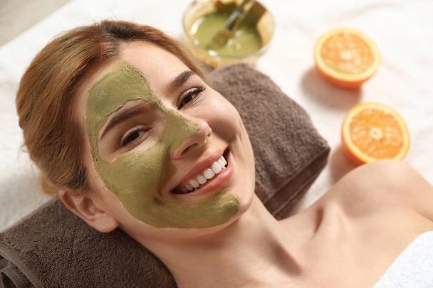 Mooie vrouw met masker op gezicht ontspannen in Spa Salon, close-up - Foto, afbeelding