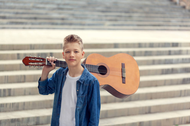 Portrait Teenager Boy with acoustic guitar in the park. - 写真・画像