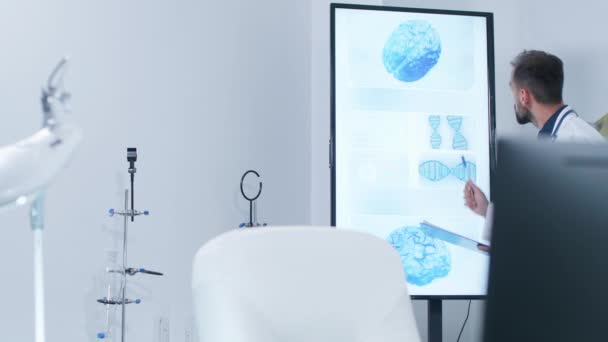 Arzt analysiert 3D-Hirnscans auf großem Monitor - Filmmaterial, Video