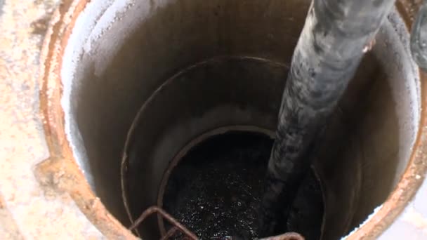 Arbeiter mit Schlauchpumpen entleeren Abwasser aus einem Entwässerungsloch. Rettungsdienst - Filmmaterial, Video