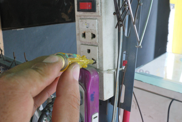 Handen met een schroevendraaier om het vermogen te meten en brand metingen uit te voeren - Foto, afbeelding