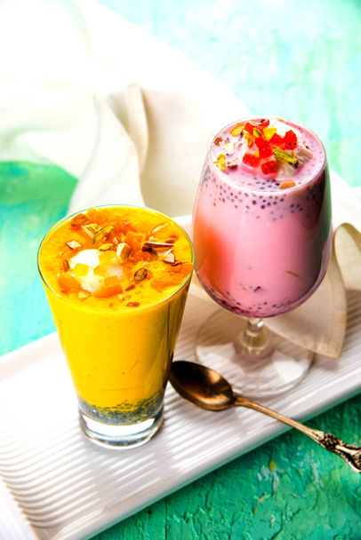 falooda / faluda ist ein beliebtes indisches Dessert - Erdbeere und Mango aromatisiert mit Eis, Nudeln, süßen Basilikumkernen und Nüssen, selektiver Fokus - Foto, Bild