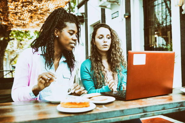 Arbeitstreffen zwischen zwei jungen Frauen vor einem Café, Witz - Foto, Bild
