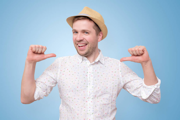 Άντρας με καλοκαιρινό καπέλο που δείχνει αυτοπεποίθηση με χαμόγελο στο πρόσωπο δείχνοντας τον εαυτό του - Φωτογραφία, εικόνα