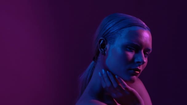 Beautiful female model posing in blue and pink neon light in studio - Séquence, vidéo