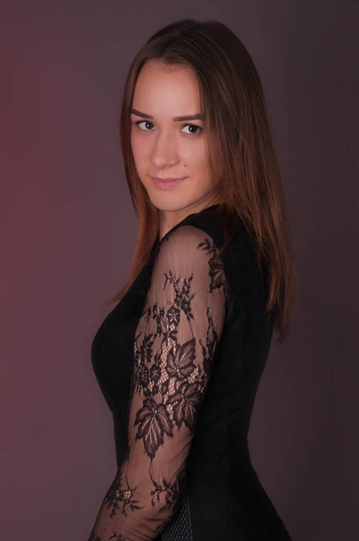 Studio portrait of beautiful brunette woman wearing dark dress - Fotoğraf, Görsel