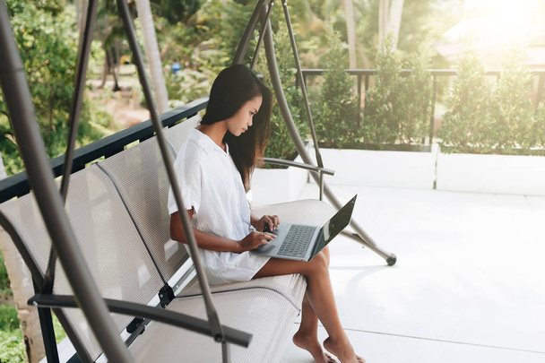 Young woman using laptop outdoors - Foto, immagini