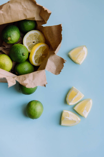 limoni e lime su fondo blu, agrumi
 - Foto, immagini