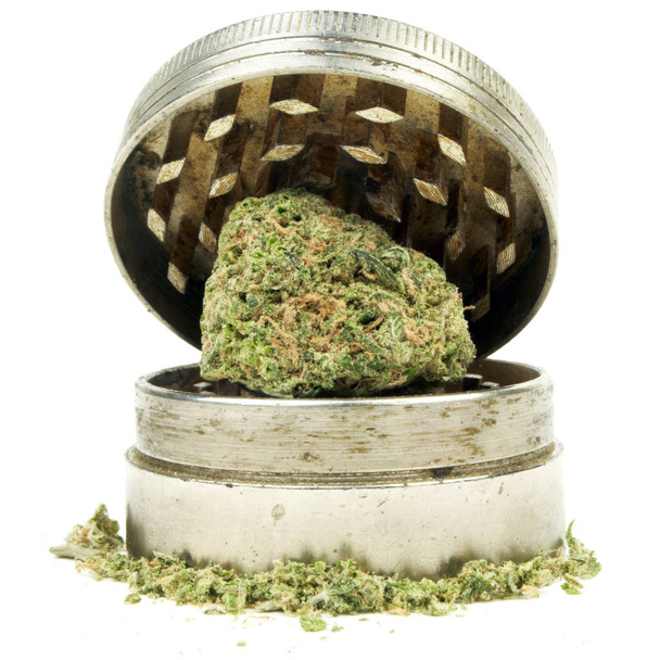 Közelről kilátás szárított marihuána és a gyomnövény zúzó fehér alapon - Fotó, kép