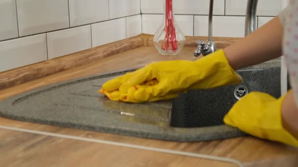 Reinigung des Spülbeckens. Frau in gelben Gummihandschuhen wäscht eine Küchenspüle. Frau in gelben Gummihandschuhen wäscht eine Spüle. - Filmmaterial, Video