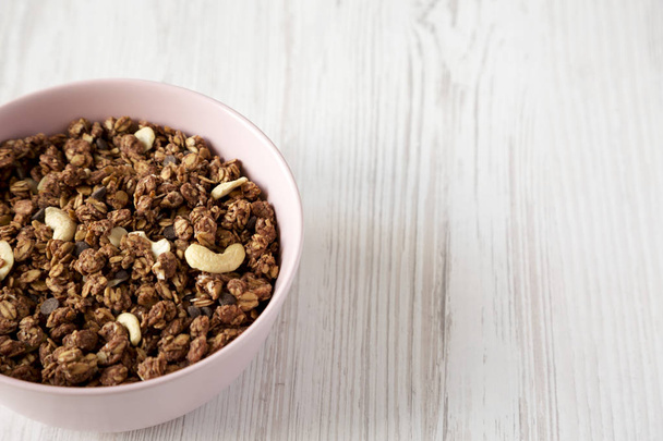 Homemade chocolate granola with nuts in a pink bowl, low angle v - Φωτογραφία, εικόνα