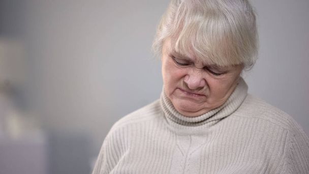 Elderly woman face close-up with disgusting expression, dementia health problem - Фото, изображение