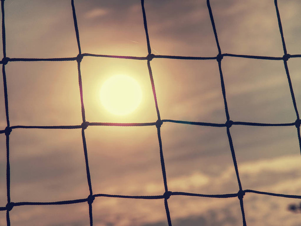 夕日のサッカーゲートネットの詳細。ゴールネット - 写真・画像