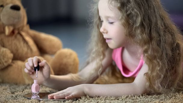 Tender little girl painting nails with polish, kid dreaming to grow up soon - Φωτογραφία, εικόνα