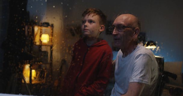 祖父と嵐を見ている少年 - 写真・画像
